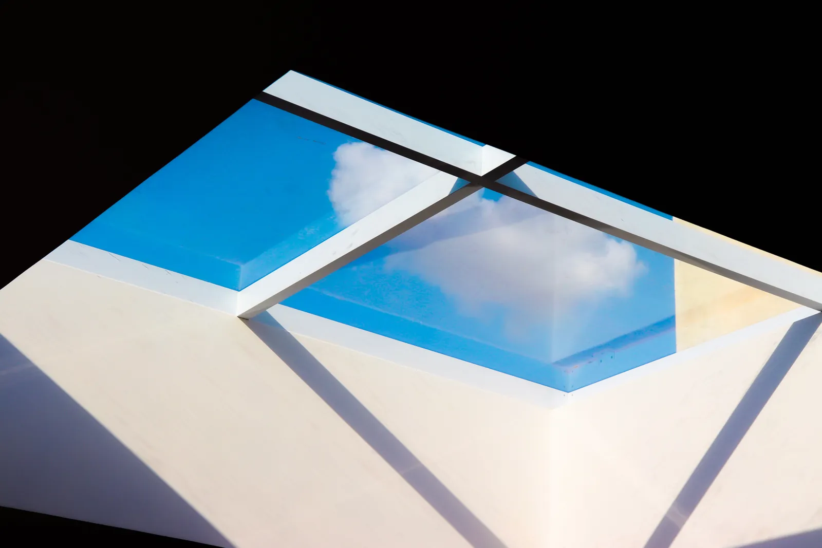 Glazen lichtstraat in een plat dak met gelaagd isolatieglas boven een woonkamer
