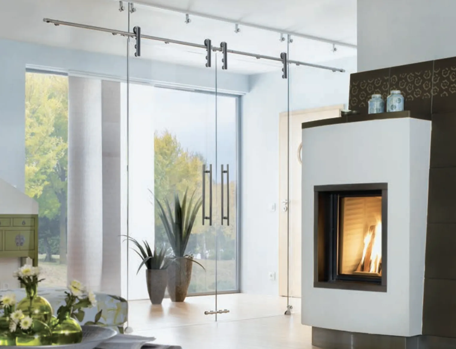 Moderne glazen taatsdeur met zwart beslag tussen hal en woonkamer